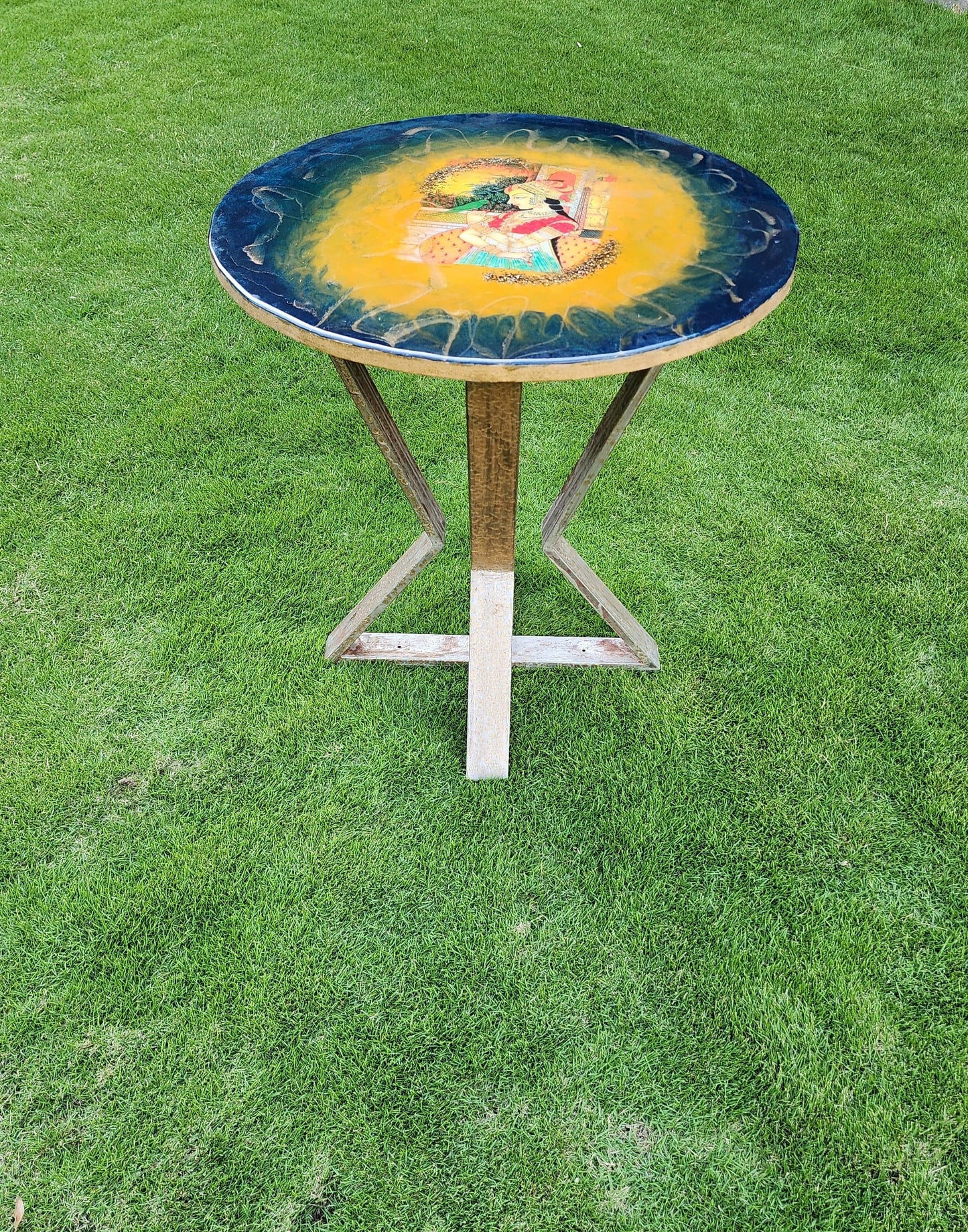 Wooden resin table with iron tripod legs. Mughal Theme
